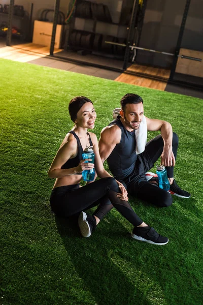 Feliz Mujer Sosteniendo Deporte Botella Con Agua Mientras Está Sentado —  Fotos de Stock