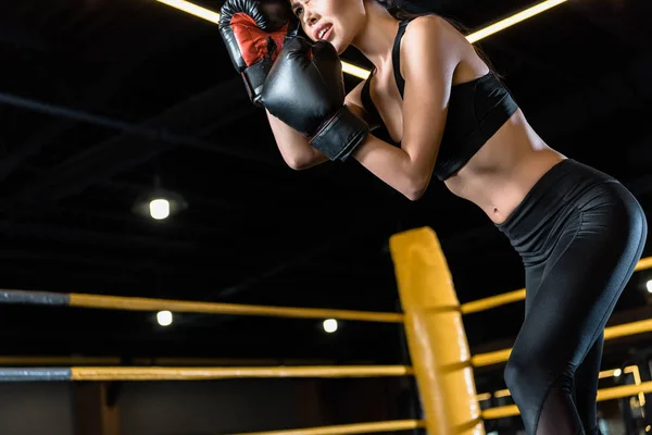 拳击手套中年轻女子拳击的低角度视角 — 图库照片