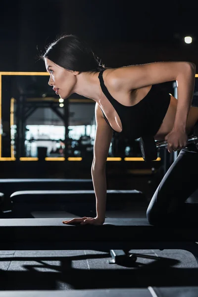漂亮和运动的女人在健身房用哑铃锻炼 — 图库照片