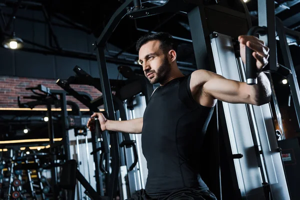 low angle view of sportsman exercising on training apparatus in gym