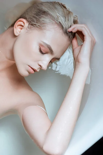浴槽の透明な水の中で目を閉じたヌード女性のトップビュー — ストック写真