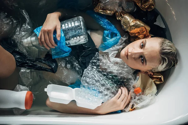 Vista Superior Mujer Joven Posando Bañera Con Basura Plástico Concepto — Foto de Stock