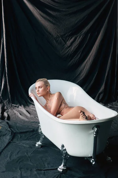 Bela Mulher Loira Molhada Sexy Deitada Banheira Olhando Para Longe — Fotografia de Stock