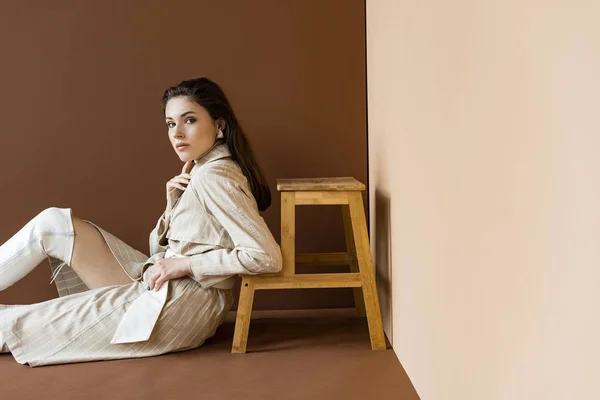 Fashionable Model Trench Coat White Boots Sitting Floor Looking Camera — Stock Photo, Image