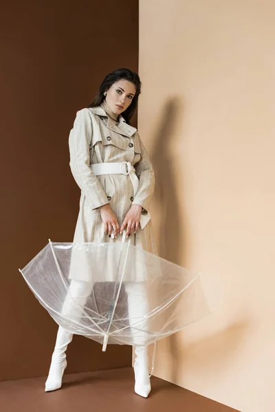 Modèle Adulte Trench Coat Tenant Parapluie Debout Sur Fond Marron — Photo