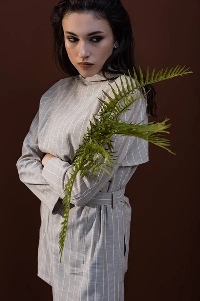 Model Holding Fern Leaves Hands Looking Away Standing Brown Background — Stock Photo, Image