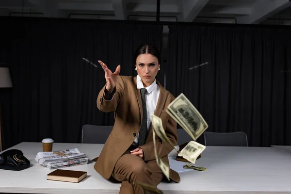 Kobieta Interesu Siedzi Stole Wyrzucając Pieniądze Patrząc Kamerę — Zdjęcie stockowe