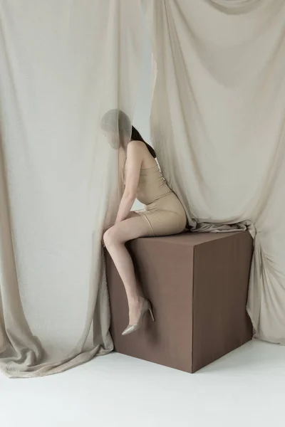 Молодая Модель Платье Сидит Кубе Светлым Занавесом — стоковое фото