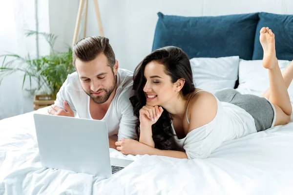 Casal Feliz Olhando Para Tela Laptop Enquanto Deitado Cama Editorial — Fotografia de Stock