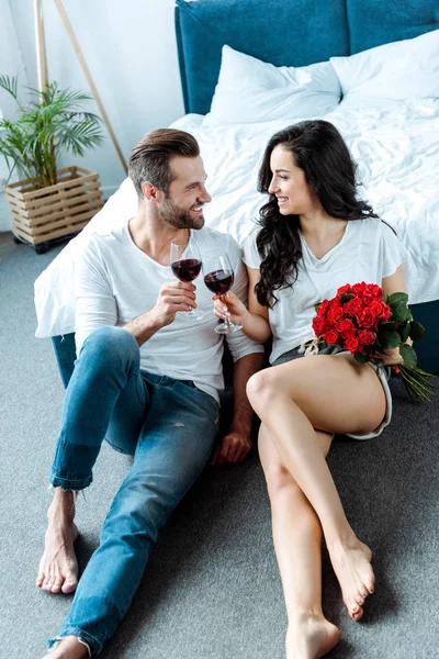 Casal Feliz Clinking Com Copos Vinho Tinto Mulher Segurando Rosas — Fotografia de Stock