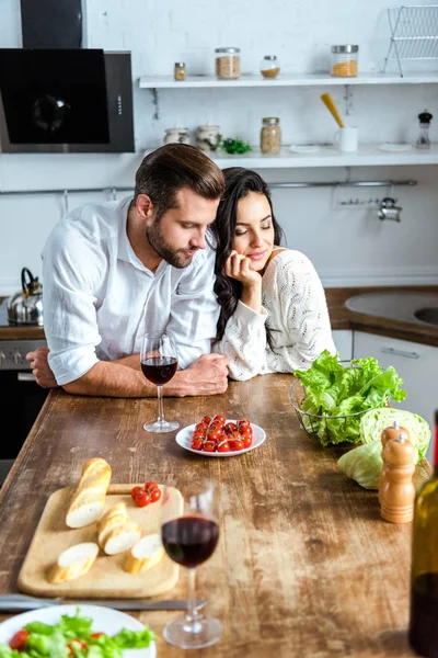 梦幻般的年轻夫妇附近的木桌与红酒 樱桃西红柿 面包和沙拉 — 图库照片