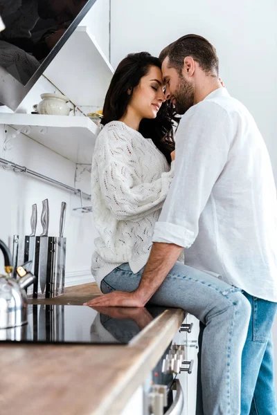 Aantrekkelijke Vrouw Zittend Tafel Keuken Omarmen Man — Stockfoto