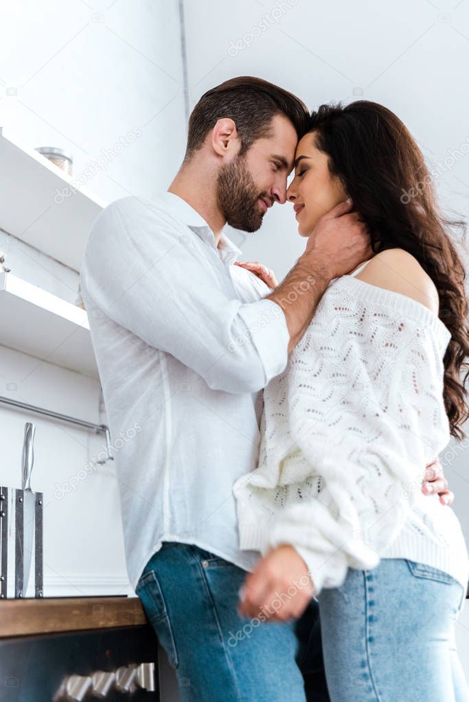 low angle view of lovely gently couple embracing at kitchen