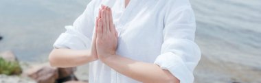 panoramic shot of young woman with praying hands  clipart