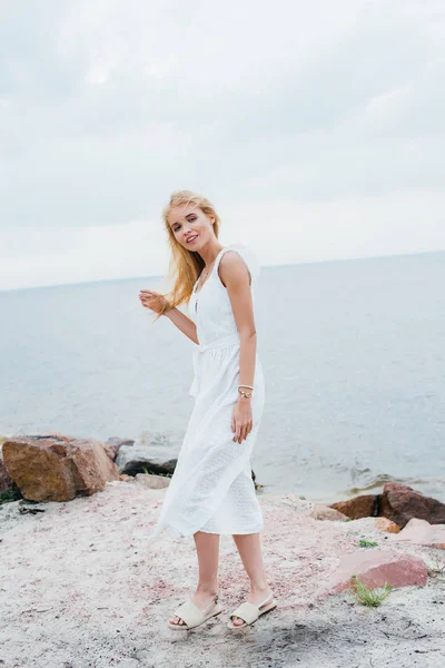 Gadis Pirang Yang Bahagia Dengan Gaun Putih Tersenyum Saat Berdiri — Stok Foto
