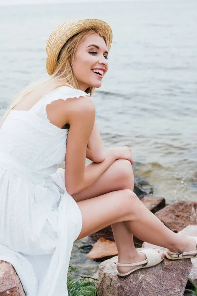 Lykkelig Blond Jente Hvit Kjole Stråhatt Smilende Nær Havet – stockfoto
