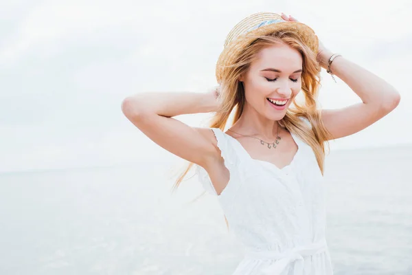 Glückliche Blonde Frau Mit Geschlossenen Augen Stehen Und Anrührendem Strohhut — Stockfoto