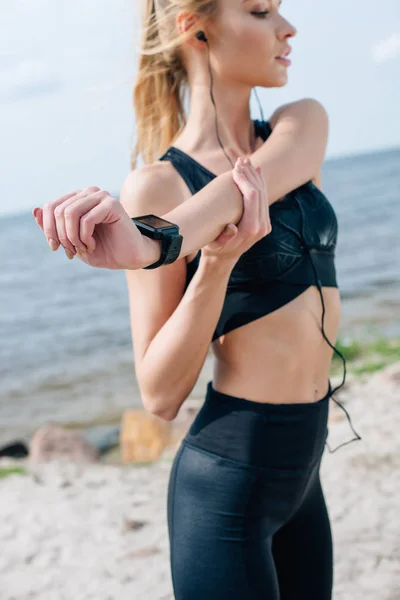 Foco Seletivo Menina Atlética Loira Alongamento Ouvir Música Perto Mar — Fotografia de Stock