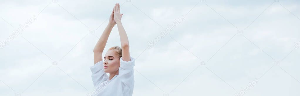 panoramic shot of attractive girl with closed eyes practicing yoga and standing with praying hands 