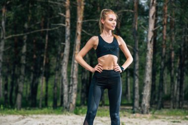 spor giyim atletik sarışın kadın kalça elleri ile ayakta 