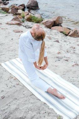 deniz kenarında yoga mat yoga kapalı gözleri ile çekici kız havai görünümü 