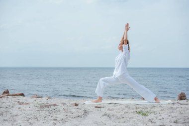 nehir kenarında yoga yapan sarışın kadının yan görünümü 