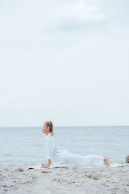 nehir kenarında yoga yapan genç kadının yan görünümü 
