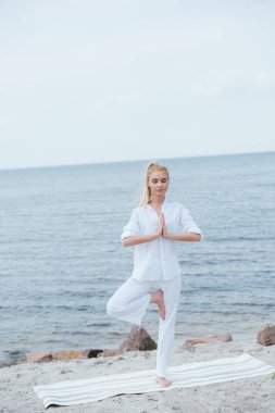 yoga mat nehir yakınında yoga yoga çekici sarışın kadın