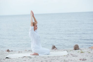 nehir yakınında baş üstü elleri ile yoga yoga çekici sarışın kadın 