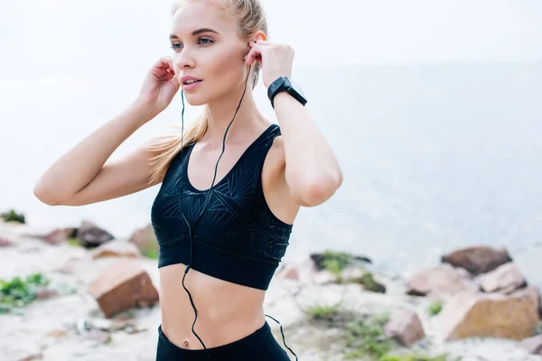 Bela Menina Atlética Tocando Fones Ouvido Ouvir Música Perto Mar — Fotografia de Stock