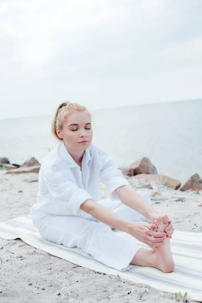 Attraktiv Blond Kvinne Med Lukkede Øyne Som Strekker Seg Yogamatte – stockfoto