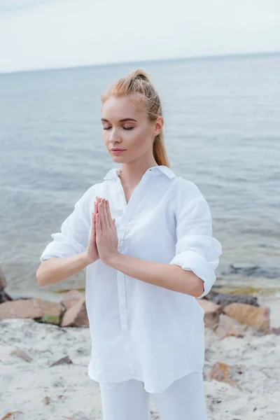 Kapalı Gözleri Deniz Kenarında Dua Elleri Ile Çekici Genç Kadın — Stok fotoğraf