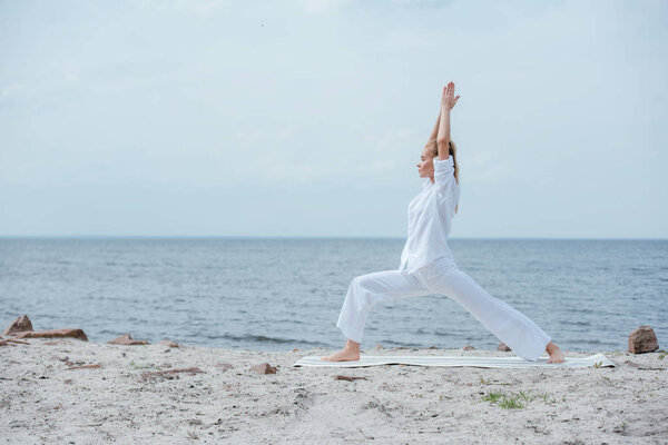 side view of blonde woman practicing yoga near river 