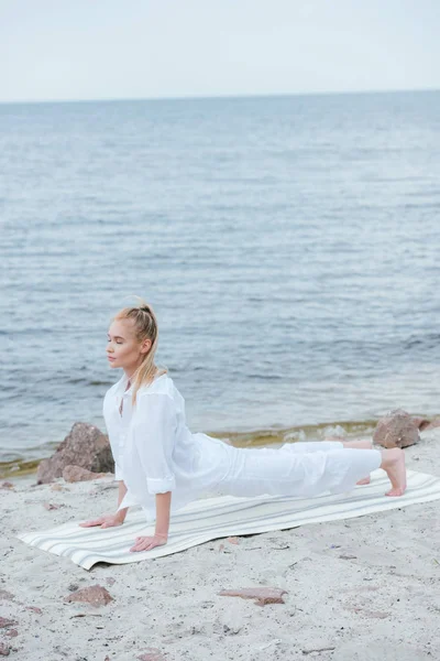 Atractiva Joven Rubia Con Los Ojos Cerrados Practicando Yoga Cerca — Foto de Stock