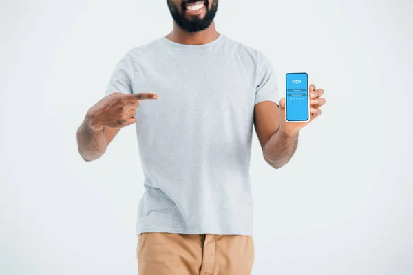 キエフ ウクライナ 2019年5月17日 スカイプアプリでスマートフォンを指すアフリカ系アメリカ人男性のトリミングビュー 灰色で隔離 — ストック写真