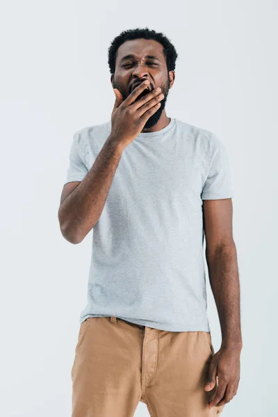 疲惫的非洲美国男子在灰色T恤打哈欠隔离在灰色 — 图库照片