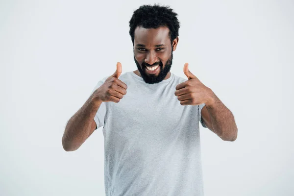 微笑的非洲美国男子在灰色T恤显示竖起大拇指隔离在灰色 — 图库照片
