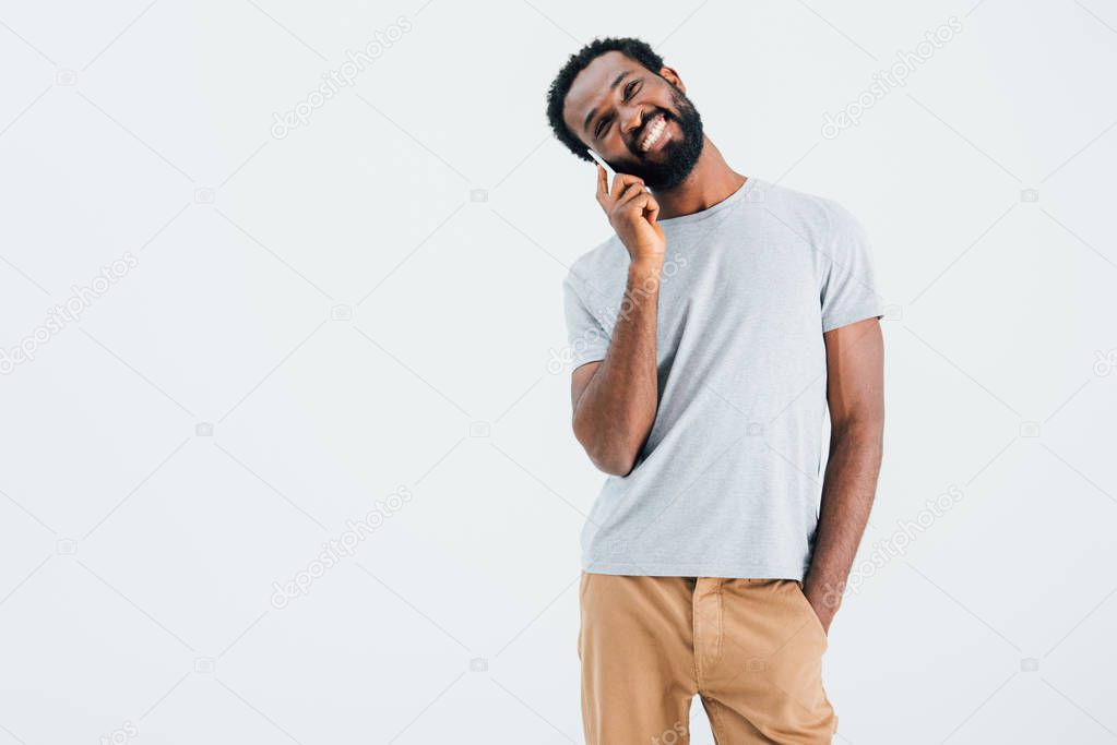 happy african american man talking on smartphone, isolated on grey