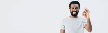 gri üzerinde izole ok işareti gösteren gri t-shirt neşeli afrikalı amerikalı adam