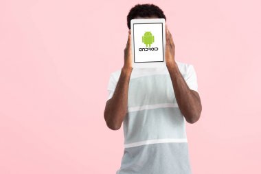 Kiev, Ukrayna - 17 Mayıs 2019: Afro-Amerikan adam bağırarak ve android uygulaması ile dijital tablet gösteren, pembe izole