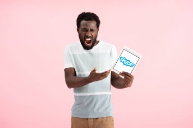 Kiev, Ukrayna - 17 Mayıs 2019: duygusal afro-amerikan adam bağırıyor ve skype uygulaması ile dijital tablet gösteren, pembe izole