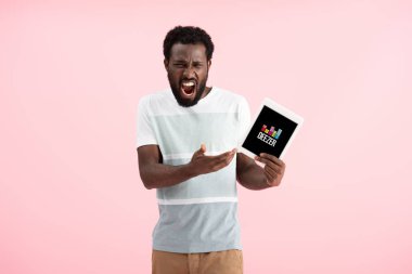 Kiev, Ukrayna - 17 Mayıs 2019: duygusal afro-amerikan adam bağırarak ve deezer uygulaması ile dijital tablet gösteren, pembe izole