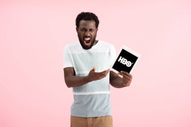 Kiev, Ukrayna - 17 Mayıs 2019: duygusal afro-amerikan adam bağırarak ve Hbo uygulaması ile dijital tablet gösteren, pembe izole