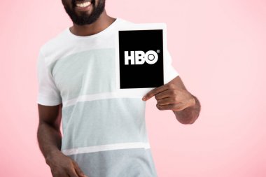 Kiev, Ukrayna - 17 Mayıs 2019: Hbo uygulaması ile dijital tablet gösteren Afrikalı Amerikalı adamın kırpılmış görünümü, pembe izole