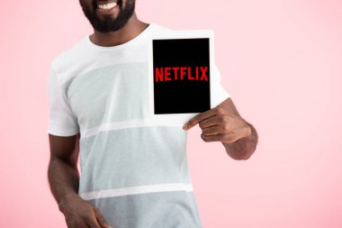 Kiev, Ukrayna - 17 Mayıs 2019: netflix uygulaması ile dijital tablet gösteren Afrikalı Amerikalı adamın kırpılmış görünümü, pembe izole