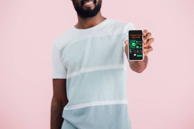 pazarlama analizi uygulaması ile akıllı telefon gösteren Afrikalı Amerikalı adam kırpılmış görünümü, pembe izole 