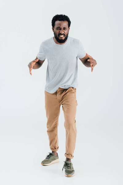 aggressive african american man in grey t-shirt posing isolated on grey