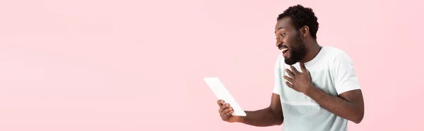 ピンクで隔離されたデジタルタブレット上のビデオチャットを持つ驚いたアフリカ系アメリカ人男性 — ストック写真