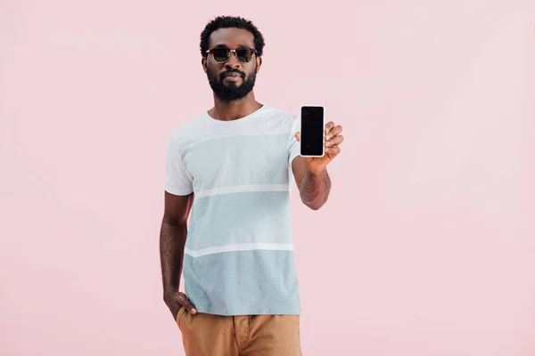 ピンクの画面でスマートフォンを保持サングラスをかけたアフリカ系アメリカ人男性 — ストック写真