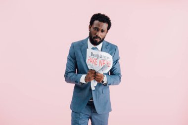 pembe izole sahte haber ile gazete tutan afro-amerikan işadamı üzgün